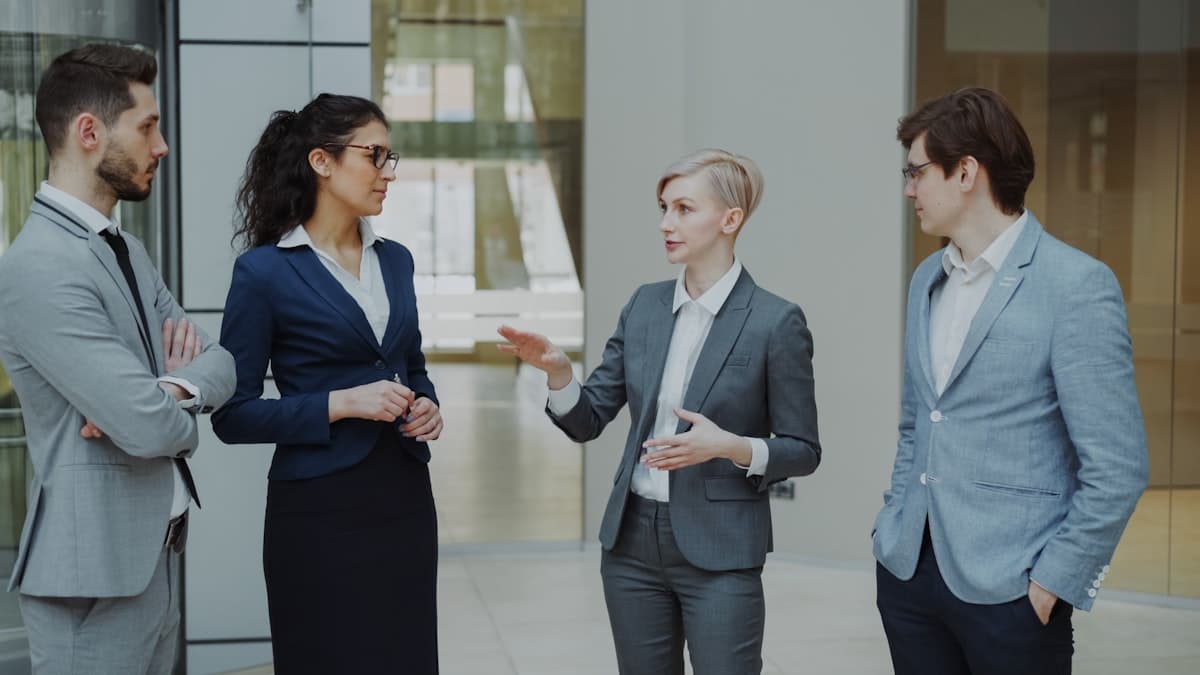 Four business professionals in a meeting discussing ideas in a modern office