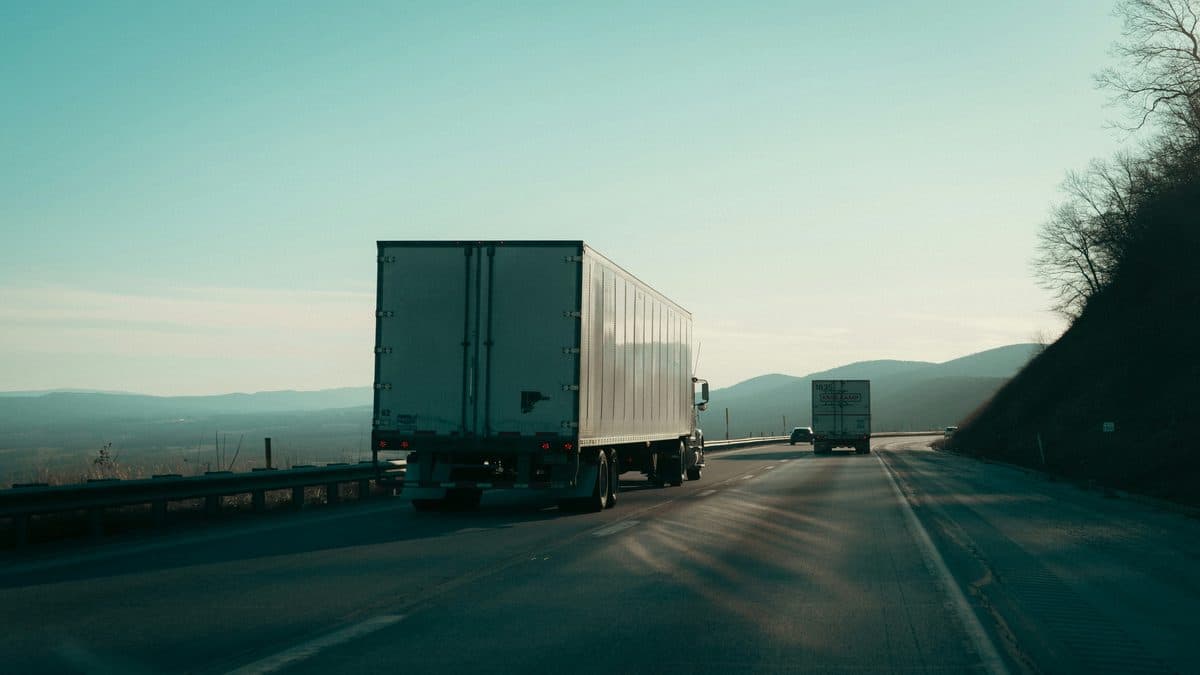Two semi-trucks driving on a mountain highway