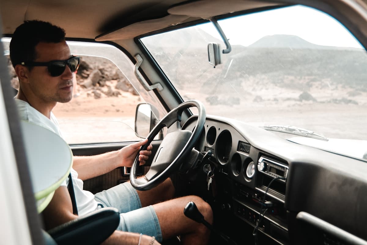Man in sunglasses behind the steering wheel of a large vehicle cab